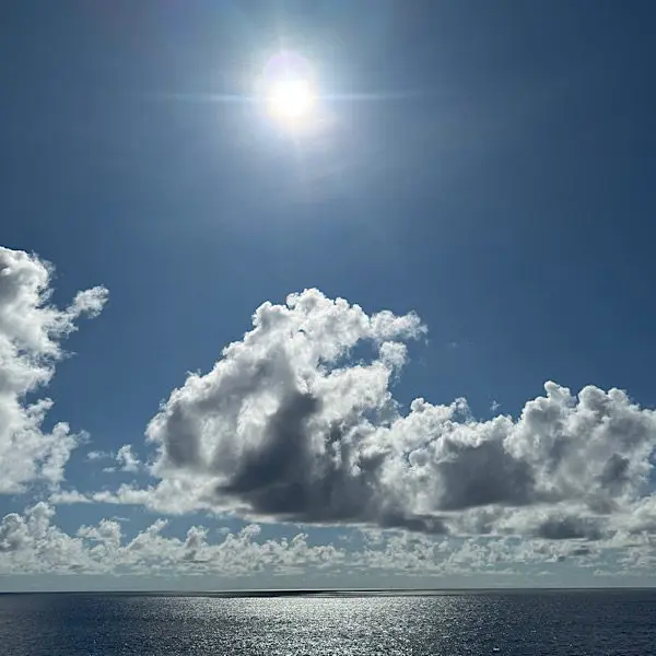Blauer Himmel mit Wolken, Sonne und ruhiges MEER