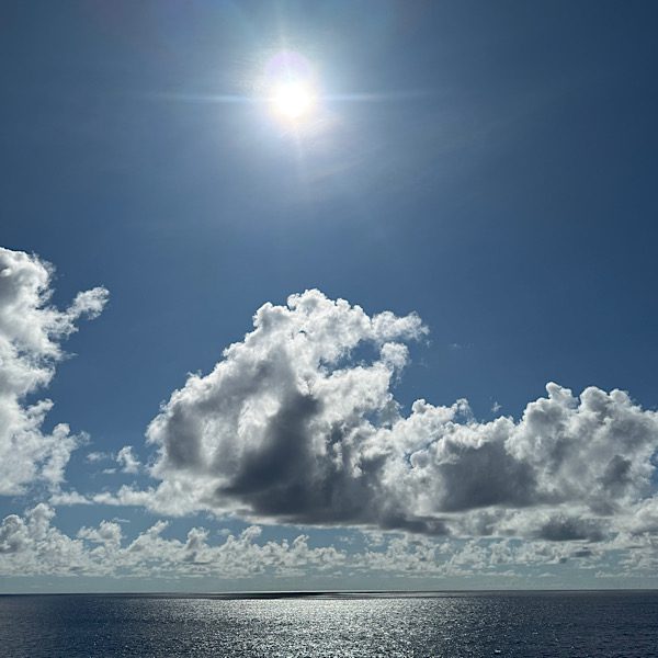 Blauer Himmel mit Wolken, Sonne und ruhiges MEER
